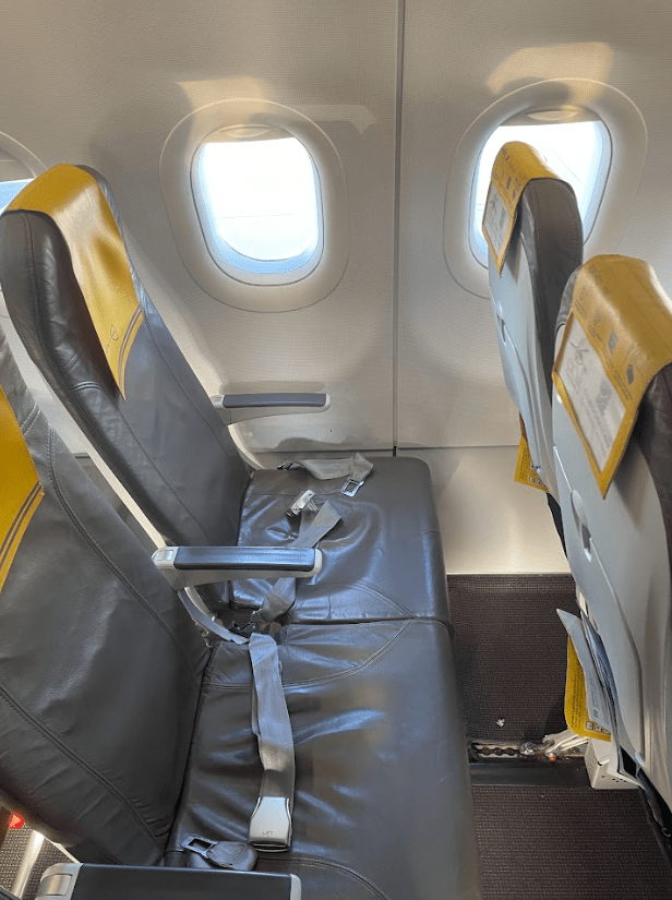Row 34 on Vueling A320 with grey seats and yellow head rest cover.