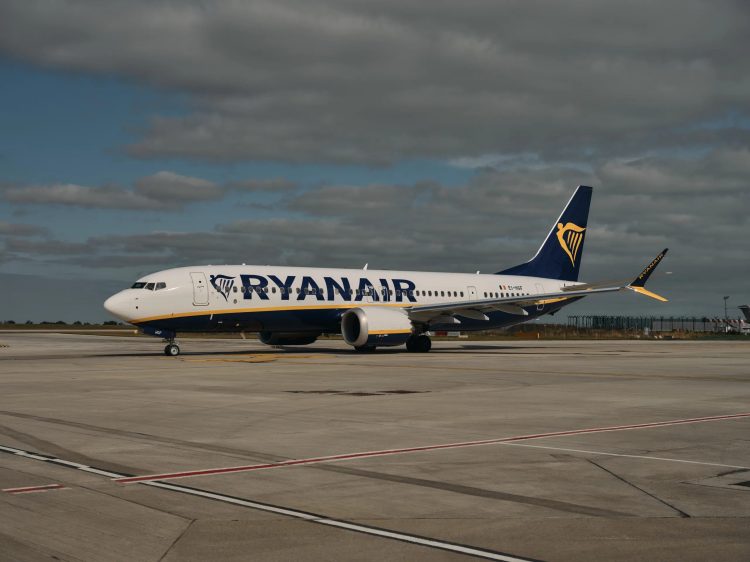 Aircraft with Blue tail and yellow harp. RYANAIR written on side of aircraft.