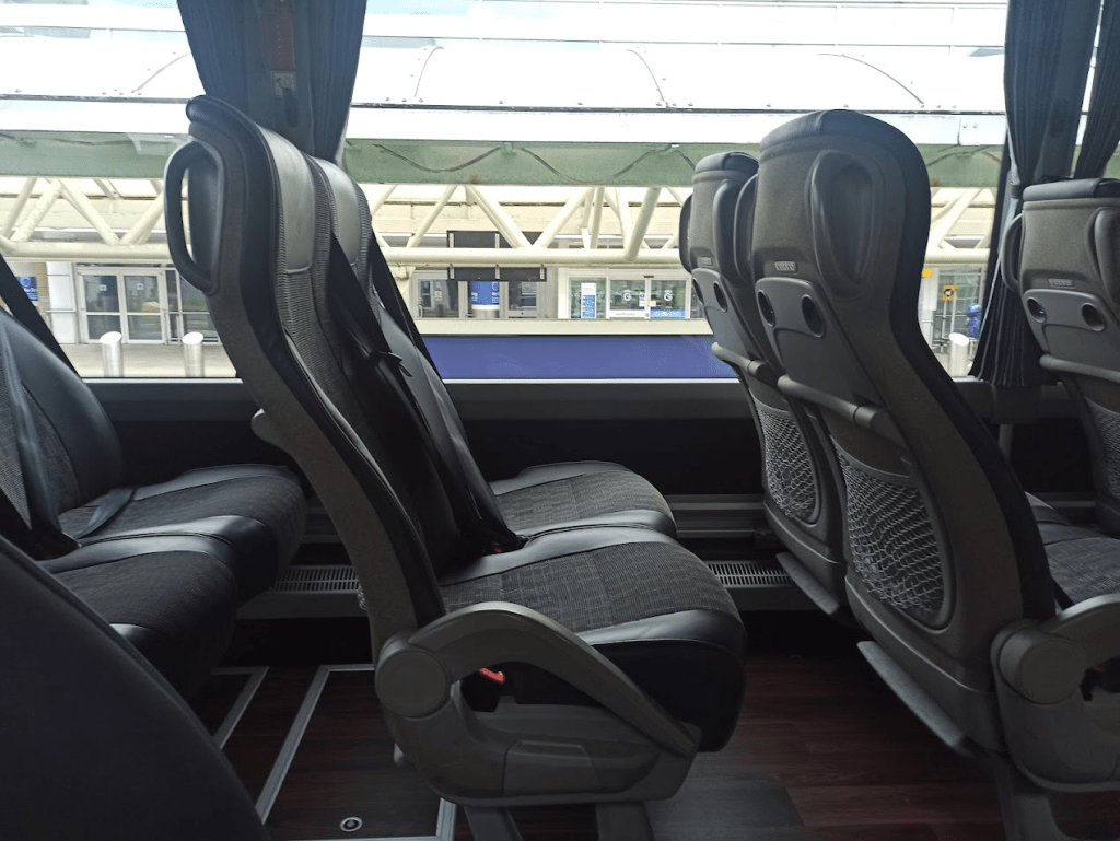 Grey seats in airline configuration with large window in background