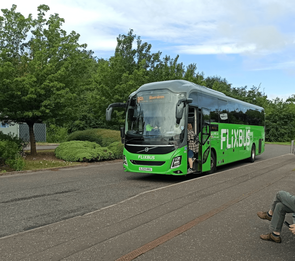 Green Flixbus parked at stop operating service 091 to Aberdeen