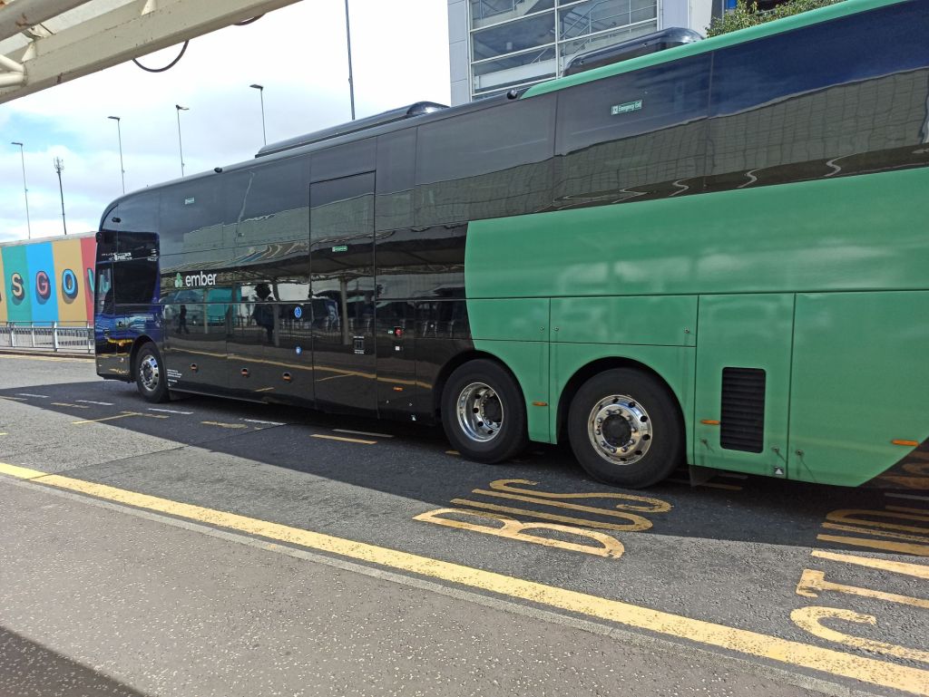 Grey and Green Ember coach leaving Glasgow Airport