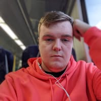 Author sitting on train with Orange Hoodie and head on hand